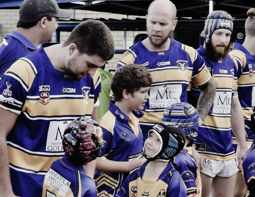 GO FOR IT: Braydon Ross looks up to a reserve grade player as the under-7 Blues and Golds form a guard of honour for Old Boys Day. 