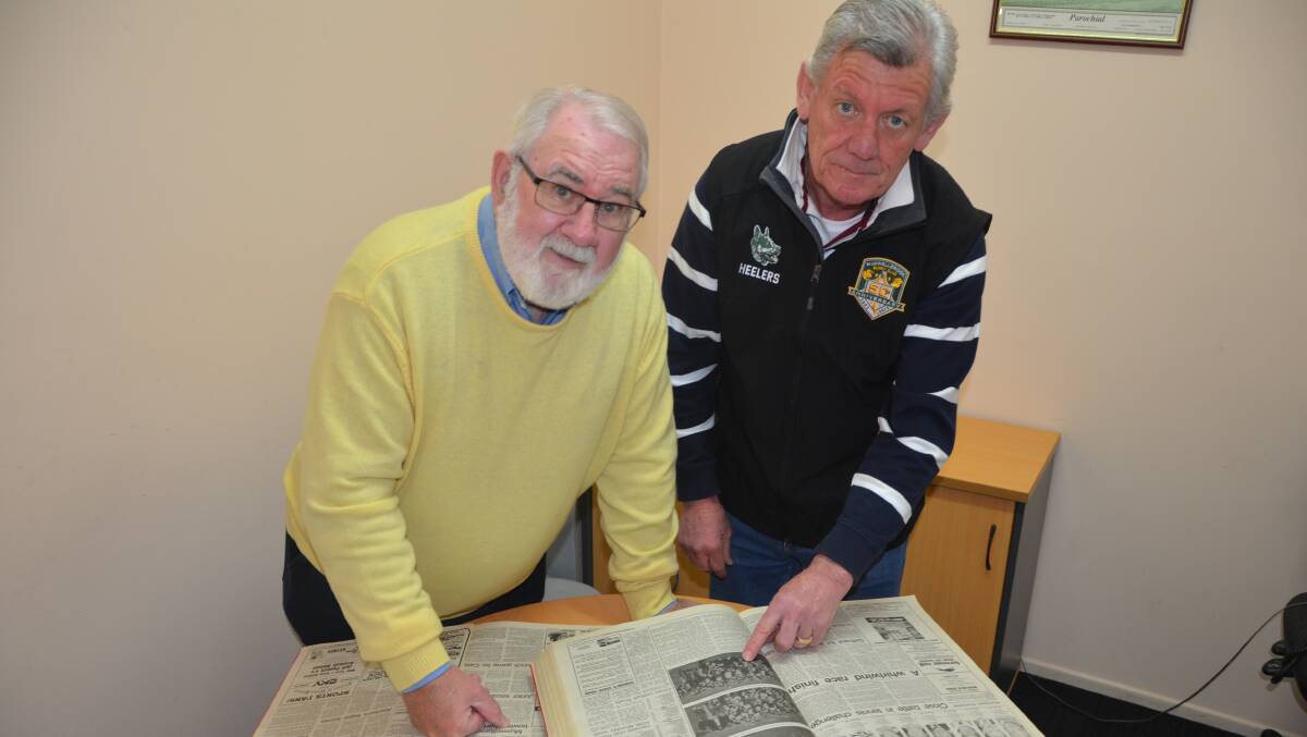 DIVING INTO THE ARCHIVES: Stan Yates and Tim Pike peruse the Muswellbrook Chronicle for Muswellbrook Heelers' press clippings.