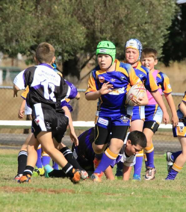 POWERING ON: Muswellbrook Rams under-10 Blues' Jacob Rousell charges into the fray against Merriwa. The side went on to win 52-6.