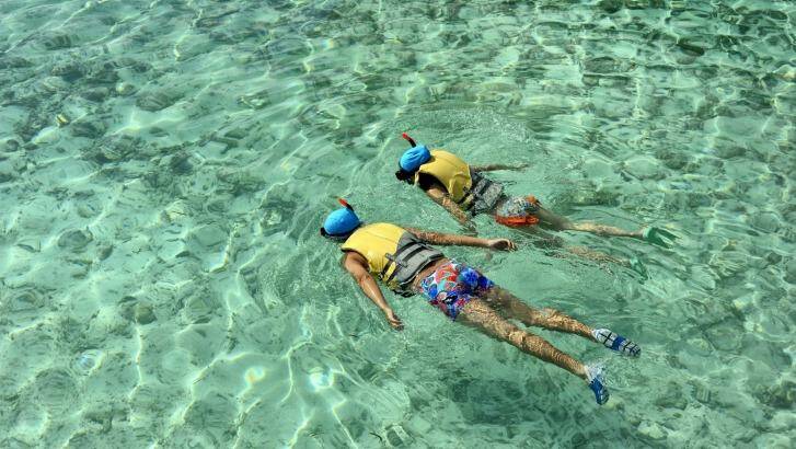 Guests snorkel off a beach near the Holiday Inn Kanduma Fushi island in the Maldives.