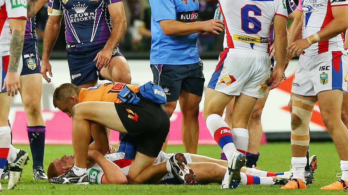 DEVASTATING: A Knights trainer comes to Alex McKinnon’s aid after Monday night’s tackle.