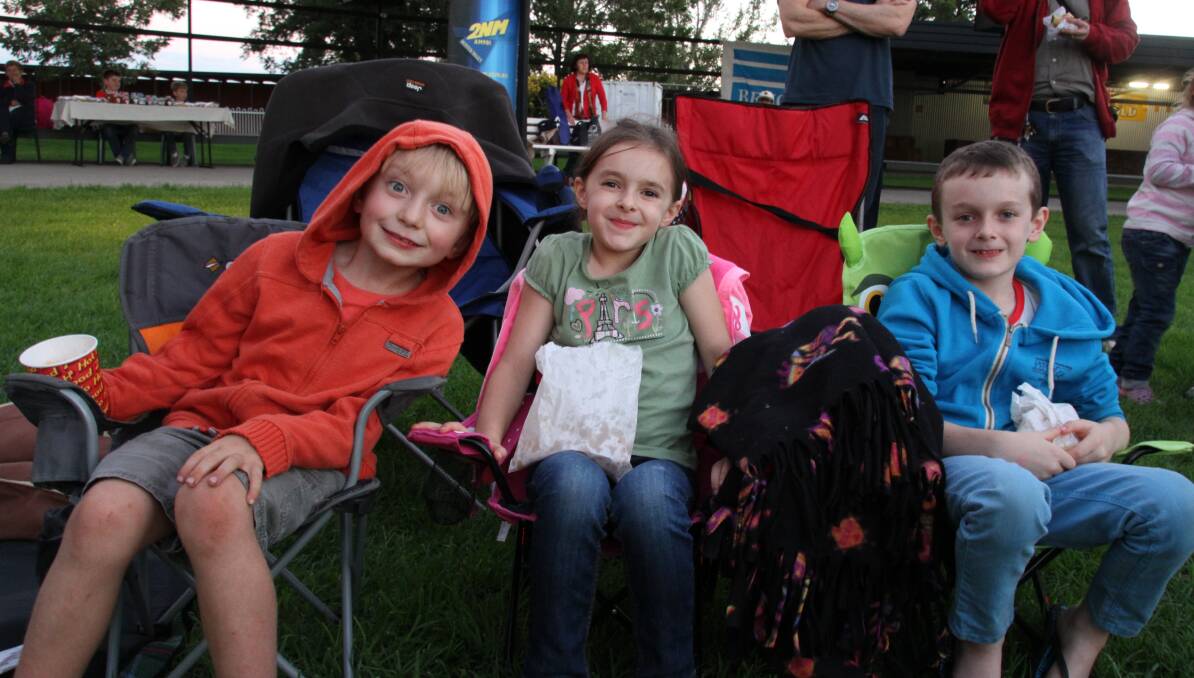 FUN TIMES AHEAD: Jack Flemming, 6, Sarah Janney, 6, and Jacob Janney, 7, with their snacks ready for the sun to go down and movies to start.