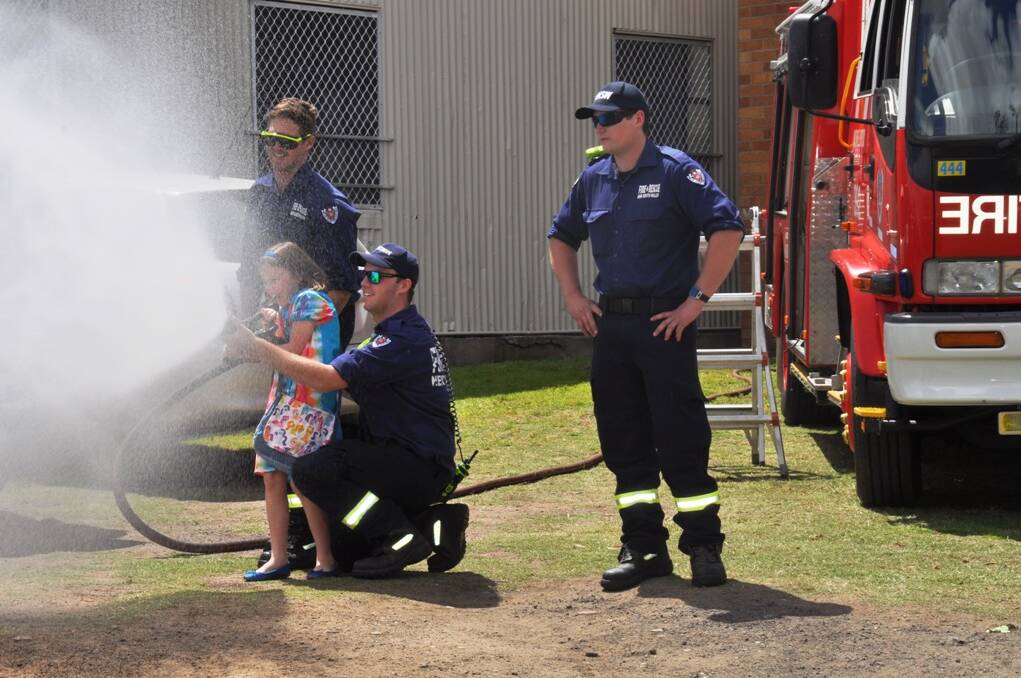 Luke Simpson (left), Chris Forbes (centre) and Cody Herbert (right) showing a budding firefighter at the Fair how it's done!