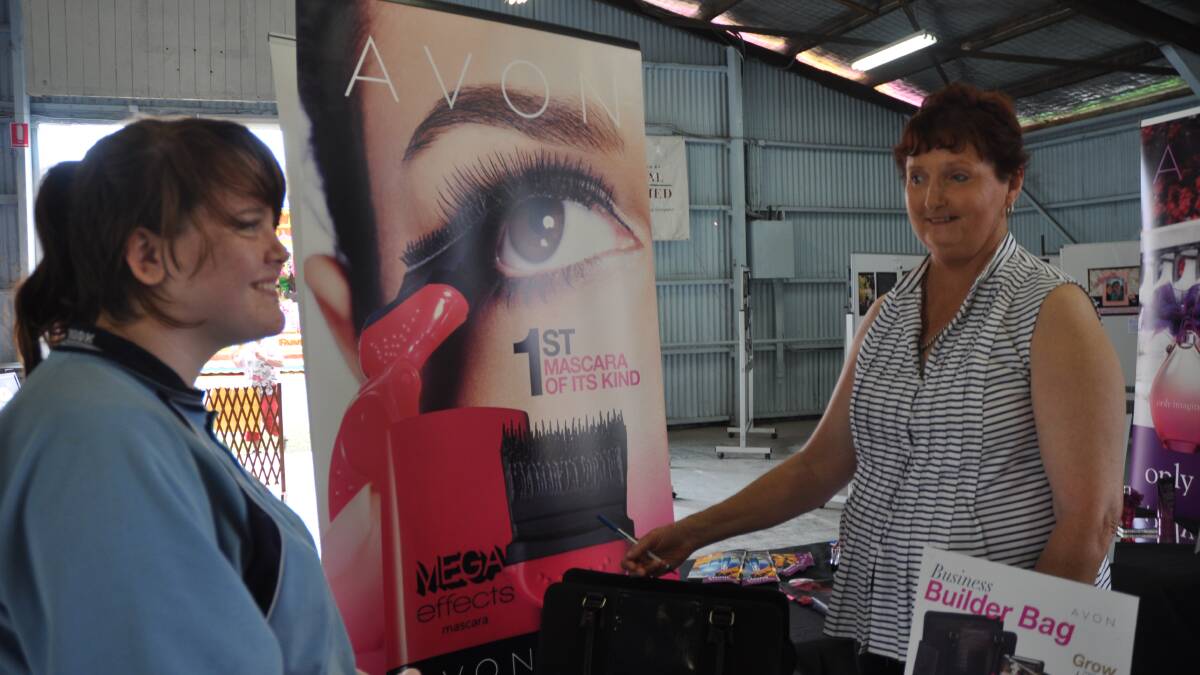 SHOW TIME: Avon stand-in manager Cheryl Moore shows Jessica Roy (left) the company’s available products at the Upper Hunter Show.