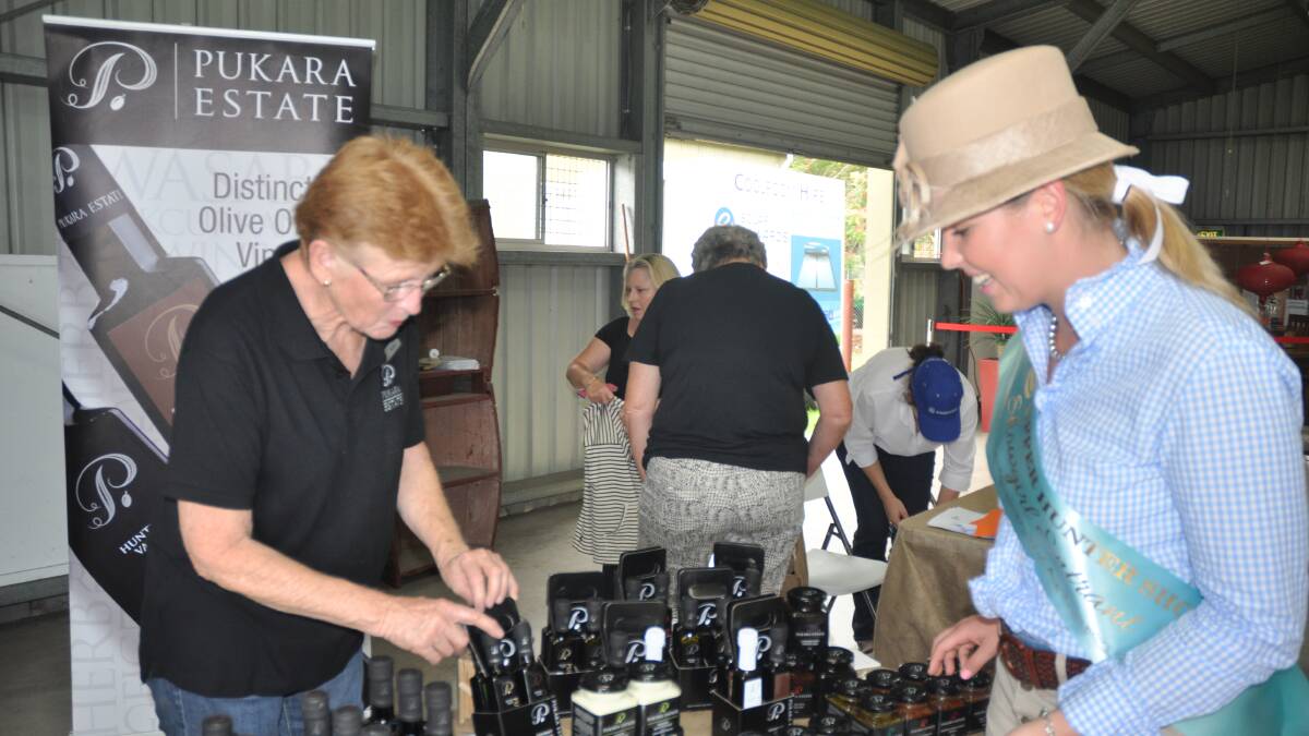 SHOW TIME: Pukara Estate’s Kris Neilson shows Upper Hunter Showgirl entrant Hannah Hunt the range of products available.