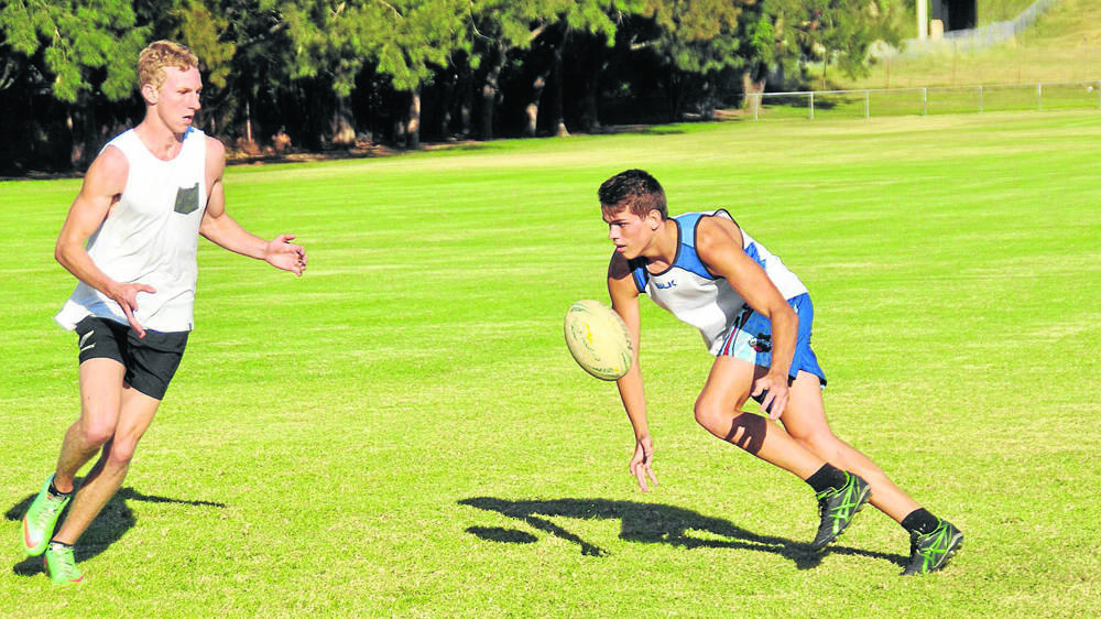 GOOD HANDS: Brandy Hardy gets ready to take a pass from Seaton Graham at under-18s training.