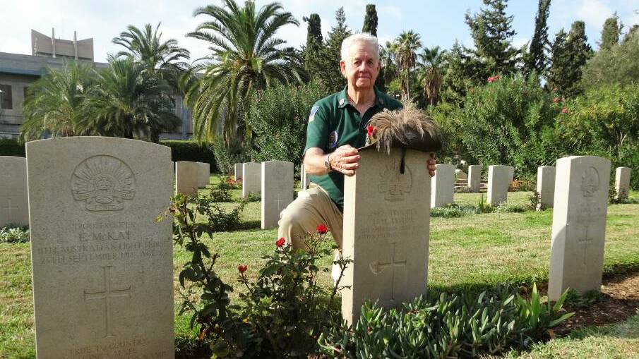 Wearing with pride: Austin Short at the grave of his grandfather, Howard Taylor, in Haifa, northern Israel. Picture: Sally Cripps.