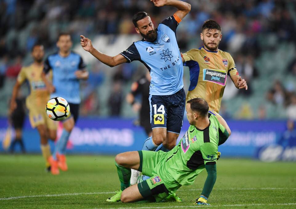 BOOTS AND ALL: Newcastle's Jack Duncan and Alex Brosque collide at Allianz Stadium on Saturday night. Picture: AAP