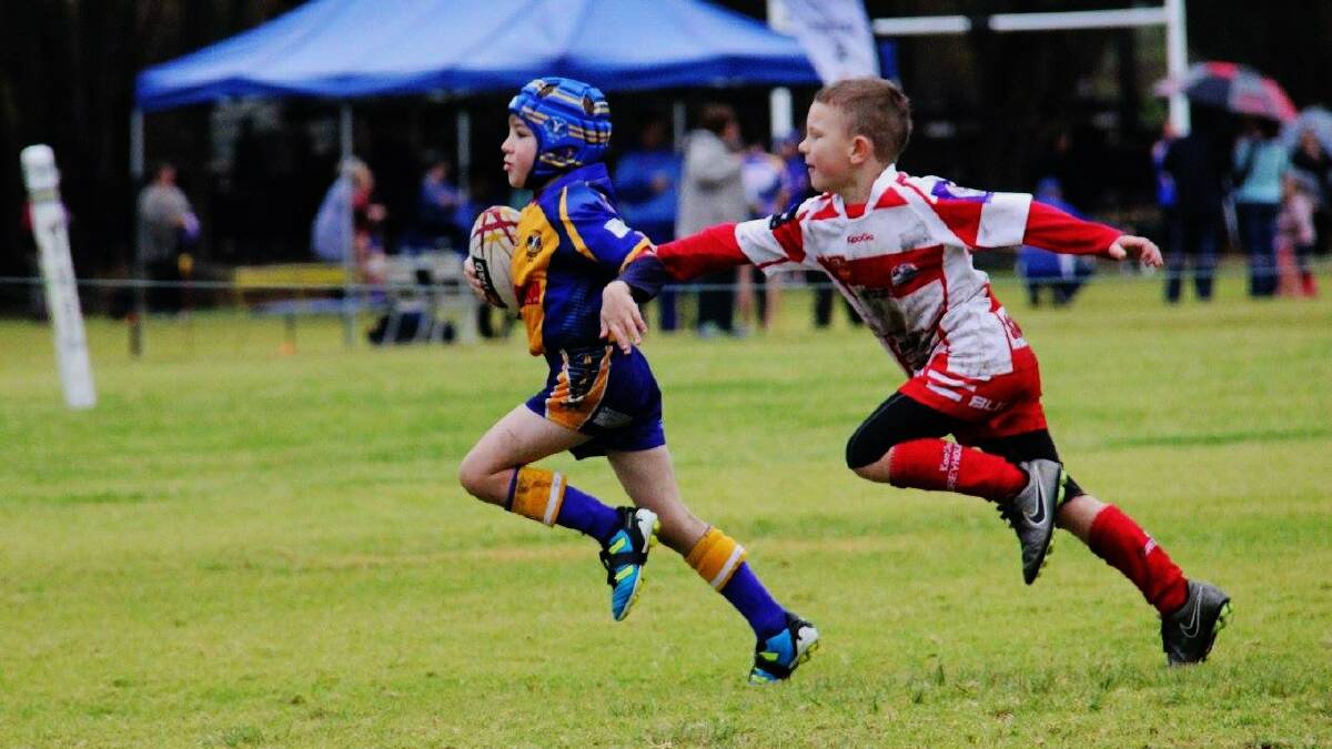 COME BACK HERE: A rival player attempts to grab onto Muswellbrook Rams under-6's Lachlan Farmer.