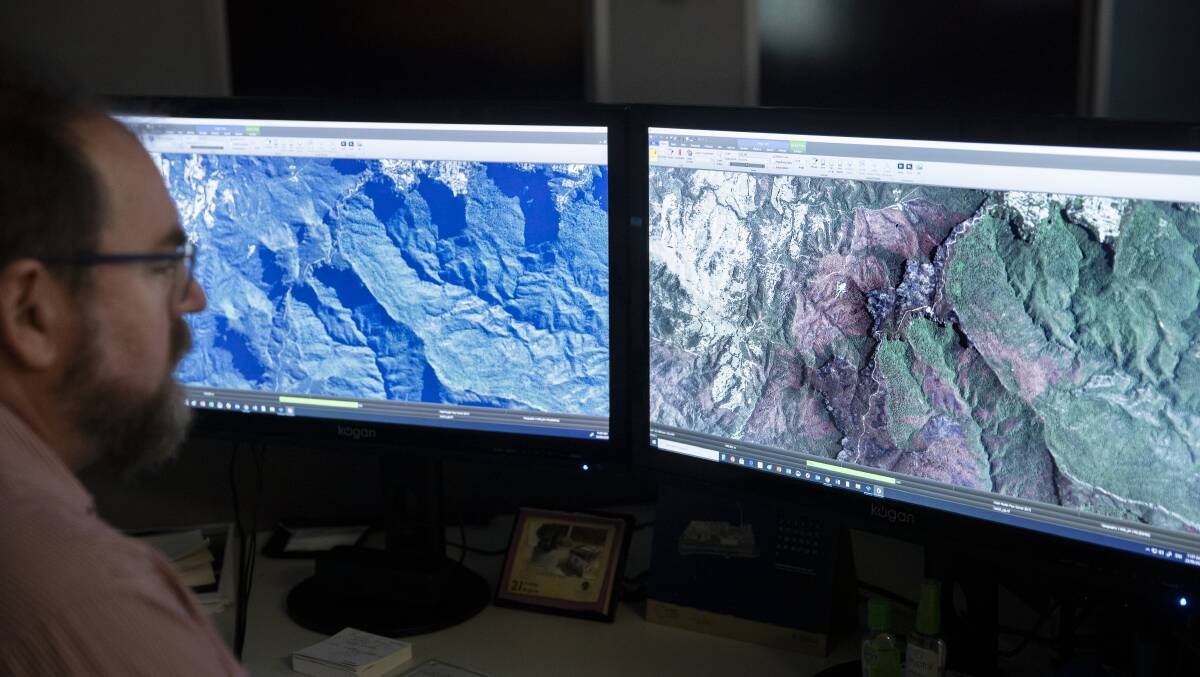 Geospatial Intelligence analyst Rick Brown examines satellite images taken before and after bushfire raged through the Blue Mountains south of Katoomba. Picture: Sitthixay Ditthavong