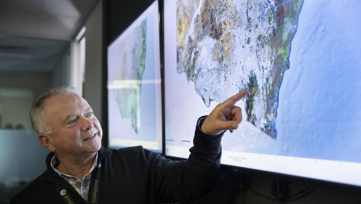 Geospatial Intelligence chief executive Rob Coorey points to areas around the ACT affected by recent bushfires. Picture: Sitthixay Ditthavong
