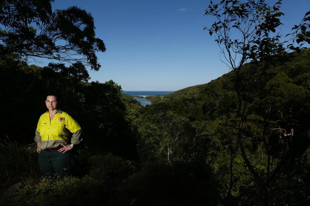 NATURAL GEM: NSW National Parks and Wildlife Service ranger Kate Harrison, with Glenrock Lagoon in the background, in 2018. Picture: Jonathan Carroll 
