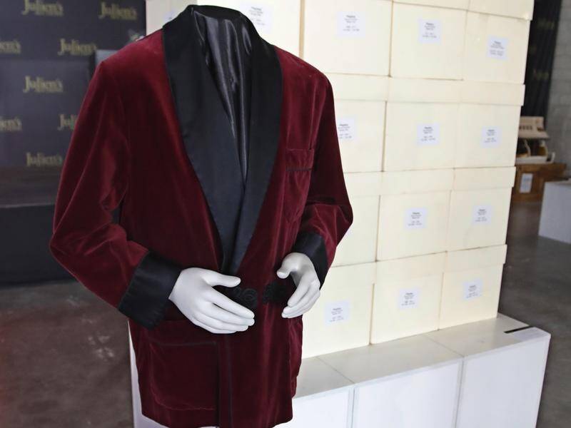 A red smoking jacket worn by Playboy founder Hugh Hefner has fetched $A56,847 at an auction.