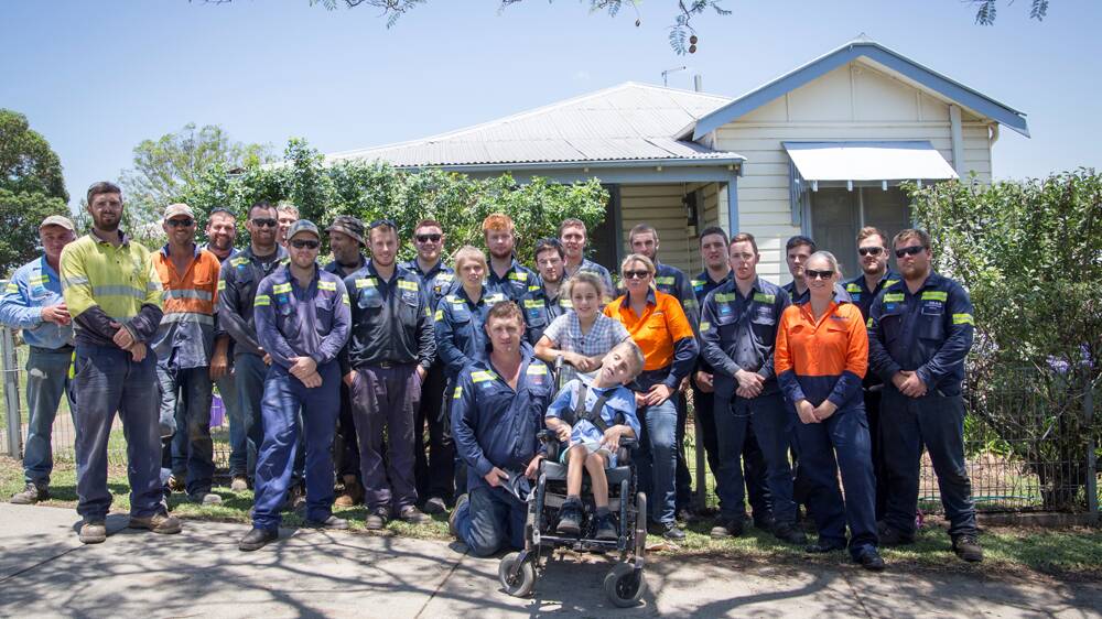 WORKING TOGETHER: Bengalla maintenance employees and apprentices stand with Jake Ballard (front centre) and Jake’s friend Josie Matthews in front of the Ballard family home.