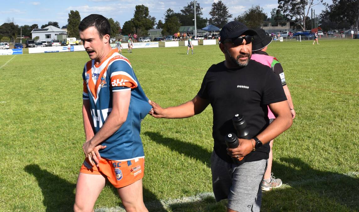 INJURY: Meerkat Brendon Chalker is escorted off the field after suffering a compound fracture in Game 21.