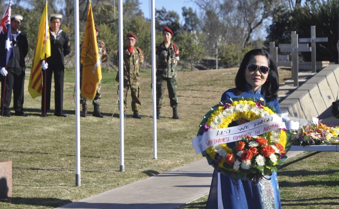 REPRESENTING THE PEOPLE: A singer from the Vietnamese choir carries a wreath on behalf of the Vietnamese community.